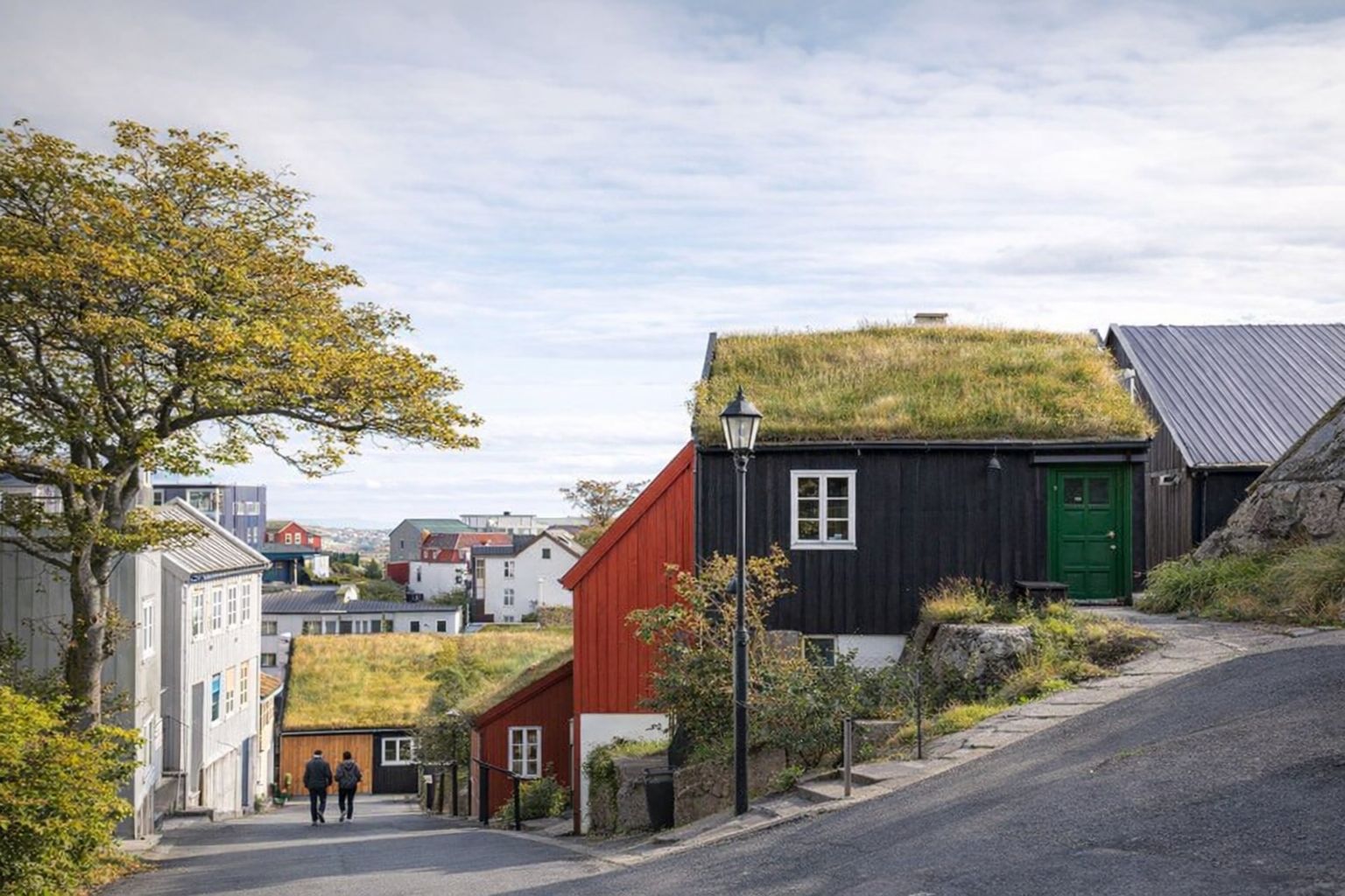 Idyllisk bymiljø med traditionelle huse og græstage, der indbyder til ro.