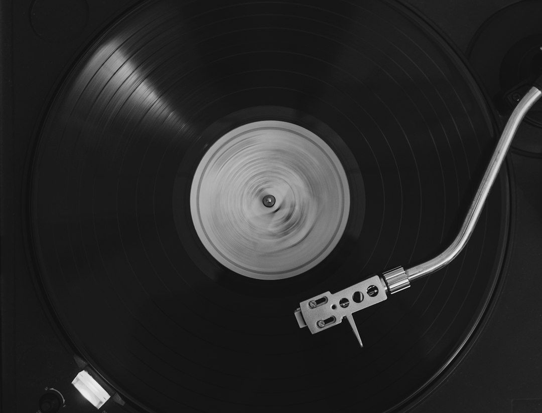 Nærbillede af en vinylplade med pickup og nål på en pladespiller